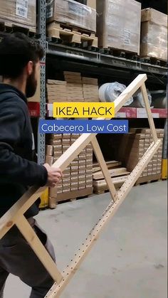 a man carrying a wooden chair in a warehouse