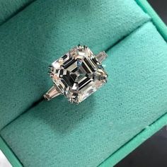 a fancy diamond ring sitting on top of a green box