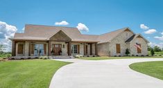 a large house in the middle of a grassy area with a flag on it's front porch