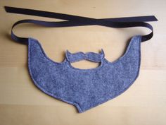 a blue felt beard and mustache on a black ribbon tied to a wooden table top