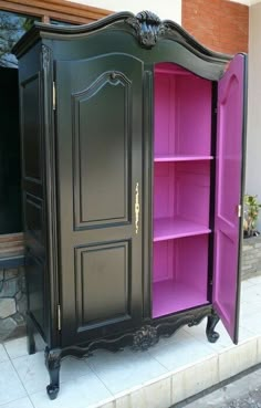 a black and pink armoire sitting on top of a sidewalk