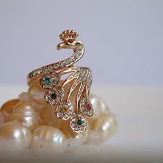 You'll be pretty as a Peacock with this costume ring on your finger and just as proud, too, for its rhinestones are sure to dazzle and delight and its elongated shape will lend an aura of elegance. The Bird measures just over 1.25 inches in length and is 7/8 inch wide from rhinestone to rhinestone. You'll find the ring to be in excellent, like new condition and ready to impress at your next soiree. Peacock Ring Design Gold, Peacock Gifts, Peacock Ring, Peacock Jewelry, Costume Rings, Ring Jewellery Design, Black Beaded Jewelry, Exotic Bird, Peridot Stone