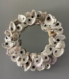 a wreath made out of seashells hangs on the wall