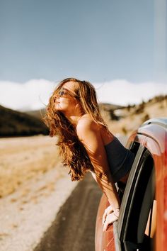 a woman leaning out the window of a car