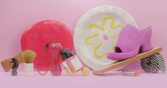 various items are arranged on a pink background