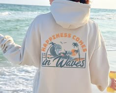 "Looking for a cozy and stylish hoodie to wear on cool summer evenings at the beach? Check out our \"Happiness Comes in Waves\" hoodie! Made from a soft and comfortable blend of cotton and polyester, this hoodie is perfect for snuggling up in after a long day in the sun or for layering on cooler beach days. The relaxed fit and cozy fabric make it perfect for throwing on over your swimsuit or pairing with your favorite denim shorts. ♥ Please let me know if you have any question about any of my pr Summer Crewneck, Summer Hoodies, Summer Hoodie, Happiness Comes In Waves, Summer Waves, Cozy Fabric, Cute Preppy Outfits, Retro Summer, Cute Simple Outfits