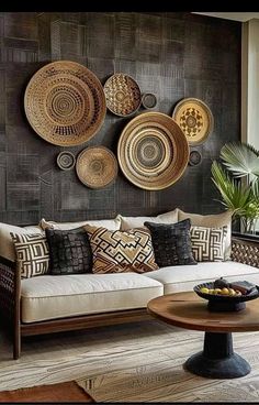 a living room filled with furniture and lots of plates hanging on the wall above it