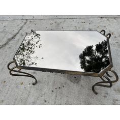 a mirror sitting on top of a cement ground