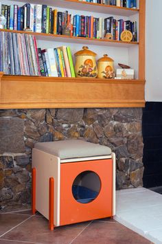 an orange and white box sitting in front of a bookshelf filled with books