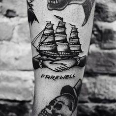 a black and white photo of a man's leg with pirate tattoos on it