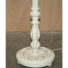 a white table lamp sitting on top of a cement floor