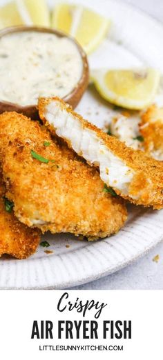 crispy air fryer fish served on a white plate with lemon wedges and tartar sauce