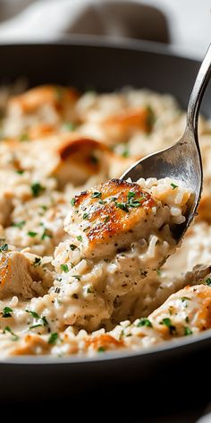 a spoonful of chicken and rice casserole being lifted from a skillet