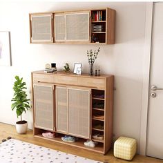 a living room with a book shelf and a potted plant