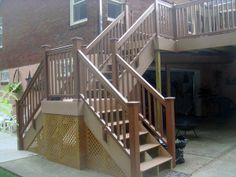 a set of stairs in front of a brick building with a patio and attached deck