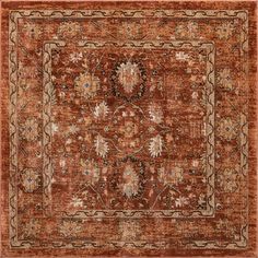 an orange and brown area rug with ornate designs on the center, in front of a white background