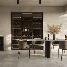 a dining room table and chairs with bottles on the shelves behind it in front of a window