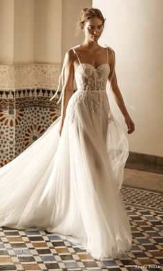 a woman in a white dress walking down a tiled floor