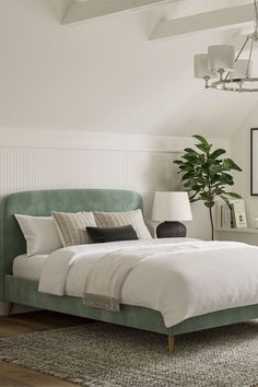 a bedroom with white walls and green headboard