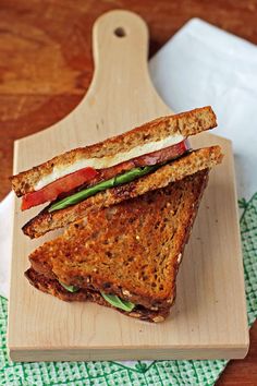 a sandwich is cut in half on a cutting board