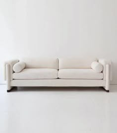 a white couch sitting on top of a white floor