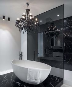 a large white bath tub sitting under a chandelier