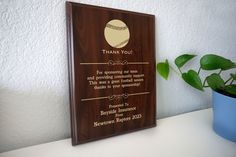 a wooden plaque with a football on it and a potted plant next to it