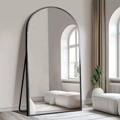 a mirror sitting on top of a wooden floor next to a white couch in a living room