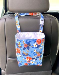 a blue flowered bag hanging from the back seat of a car