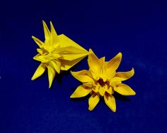 two yellow paper flowers on a blue background