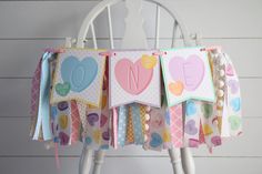 a close up of a card on a chair with paper hearts hanging from it's sides