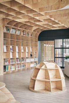 the interior of a library with wooden shelves and bookshelves on each side of the room