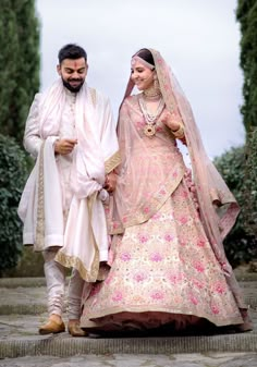 a bride and groom walking down the stairs