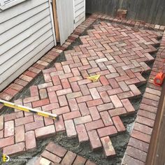 a brick patio being laid out with tools