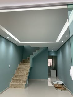 an empty room with blue walls and stairs