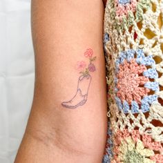 a small tattoo on the arm of a woman's left arm with flowers in it