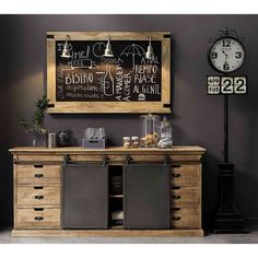 a wooden cabinet with chalkboard on the wall next to a clock and table lamp