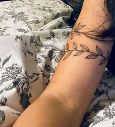 a woman with a tattoo on her arm laying in bed