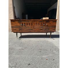 an old wooden dresser sitting in the middle of a parking lot