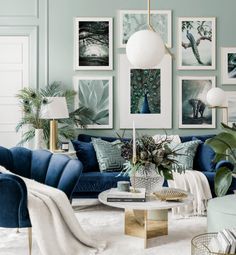 a living room filled with blue couches and pictures on the wall above them,