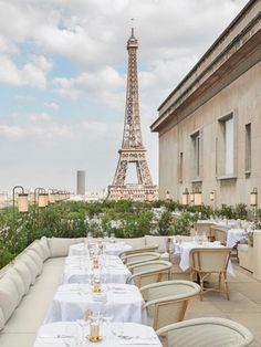 an outdoor dining area with tables and chairs in front of the eiffel tower