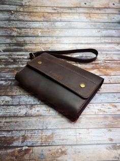 a brown leather wallet sitting on top of a wooden floor