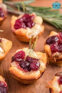 mini cranberry tarts with rosemary garnishes on a cutting board