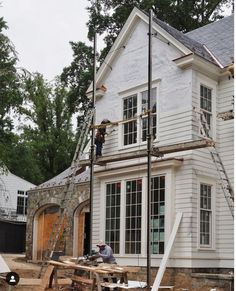 two men working on the roof of a house