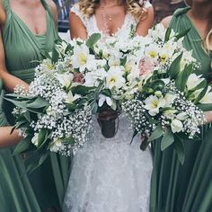 the bridesmaids are holding their bouquets with white and green flowers in them