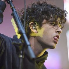 a close up of a person with ear piercings on his ears and holding a microphone