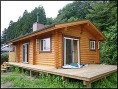 a small wooden cabin sitting on top of a lush green field