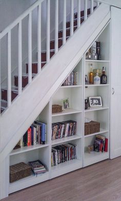 a bookshelf under a stair case filled with books