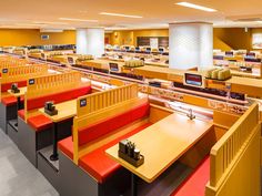 the interior of a restaurant with tables and benches