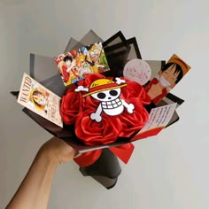 someone is holding a paper bouquet with some pictures on it and an anime character in the background